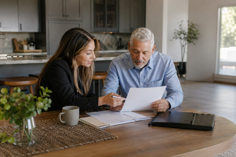 Agent reviewing Whole Life Insurance Company options with a senior at home kitchen table